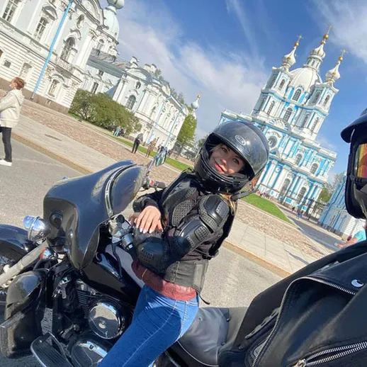 Два мотоциклиста на фоне красивой архитектуры в ясный день