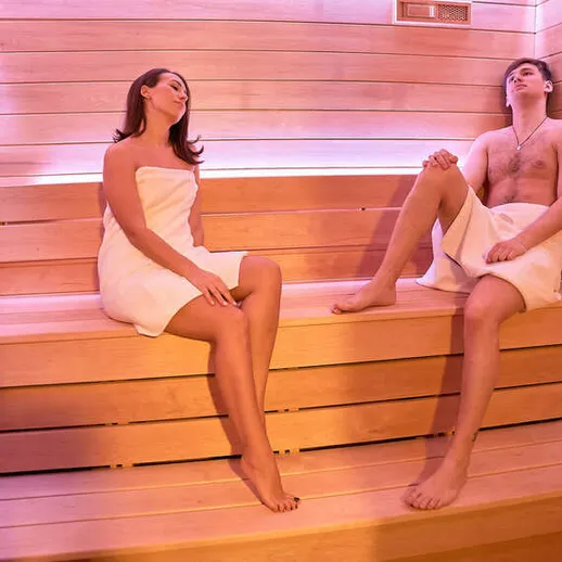 Отдых в сауне двоих людей в расслабляющей обстановке, теплый вечер и уютный свет