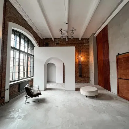 Просторное помещение с архитектурными элементами и светлыми стенами в историческом здании