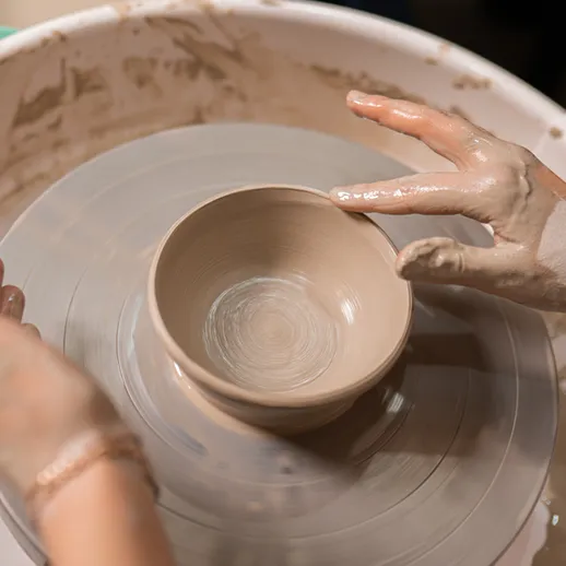 Создание керамической кружки на гончарном круге в мастерской в вечернее время