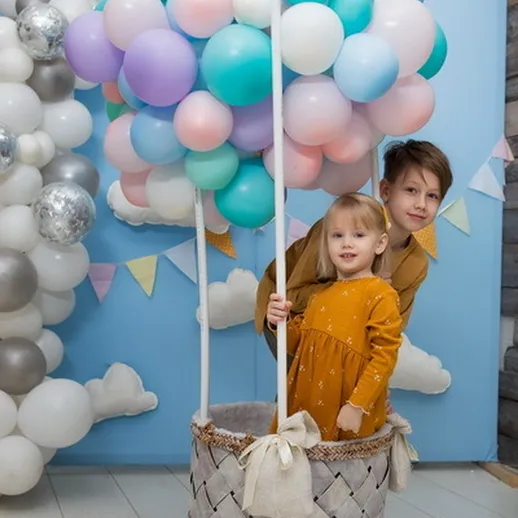 Детям весело на празднике с воздушными шарами в виде воздушного шара, украшение на фоне облаков