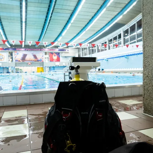 Вечерние тренировки пловцов в закрытом бассейне с современным оборудованием