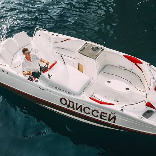 Мужчина управляет моторной лодкой в воде на солнечном дне