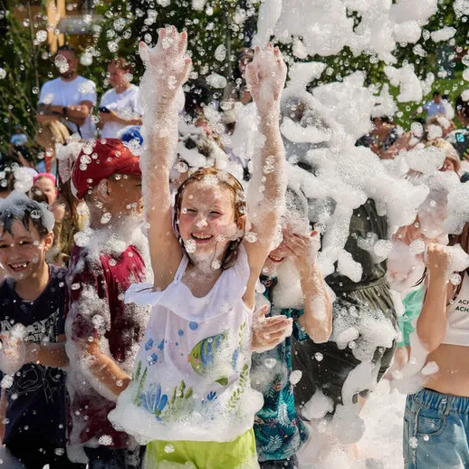 Дети веселятся на праздничном мероприятии с мыльными пузырями в теплый летний день