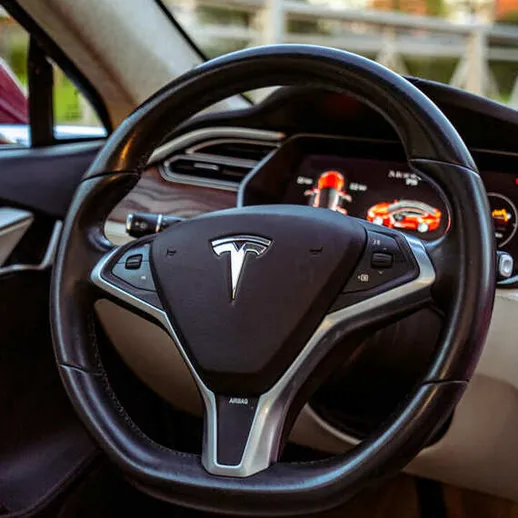 Интерьер электромобиля с видом на руль и панель управления в солнечный день