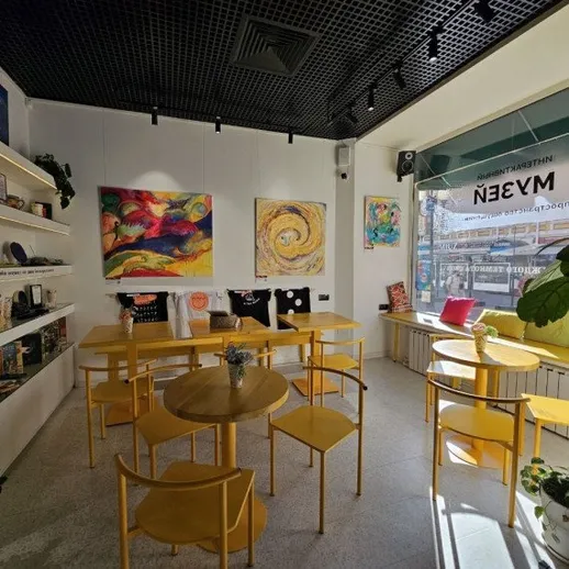 Уютное кафе с желтыми стульями и яркими картинами в центре города