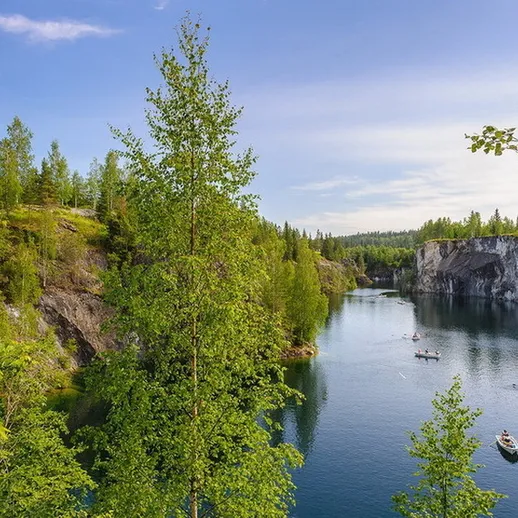 Спокойный летний день на реке в окружении леса, графитовые обрывы и лодки на воде