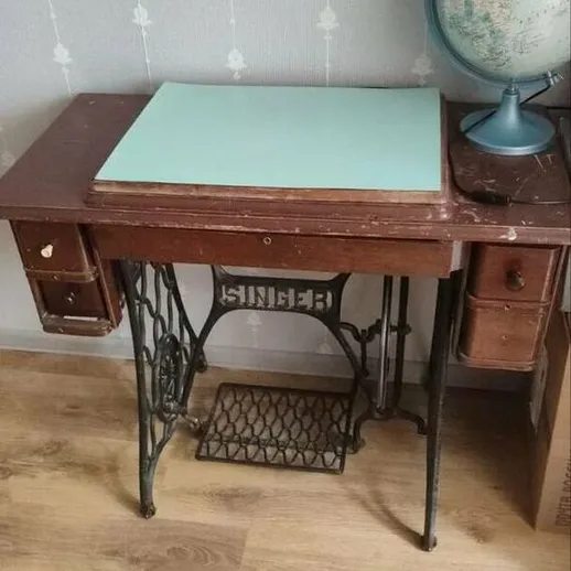 Старинный письменный стол с глобусом на фоне обоев в уютной комнате