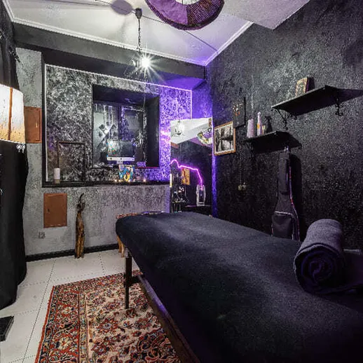 Уютный интерьер массажного кабинета с черными стенами и мягким освещением, расположенного в центре города поздним вечером