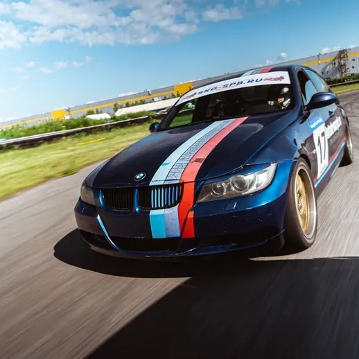 Спортивный автомобиль на трассе во время дрифта в солнечный день на автодроме