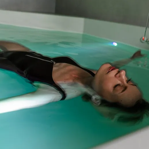 Женщина расслабляется в воде в спа-центре с светодиодной подсветкой