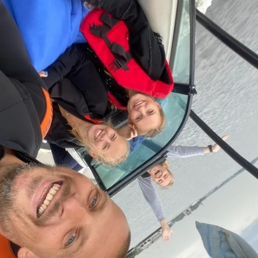 Четыре человека наслаждаются временем на катере в солнечный день у воды