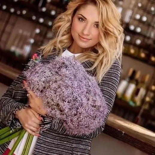 Женщина с цветами на фоне бара во время вечеринки в уютном ресторане поздней весной