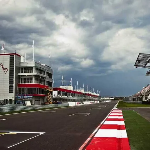 Трасса автогонок с трибунами и зданием управления во время надвигающейся грозы