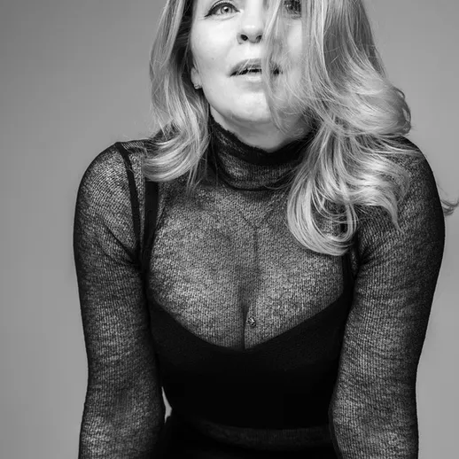 Портрет женщины в черной кофте с длинным рукавом на нейтральном фоне, сделанный в студии при мягком освещении