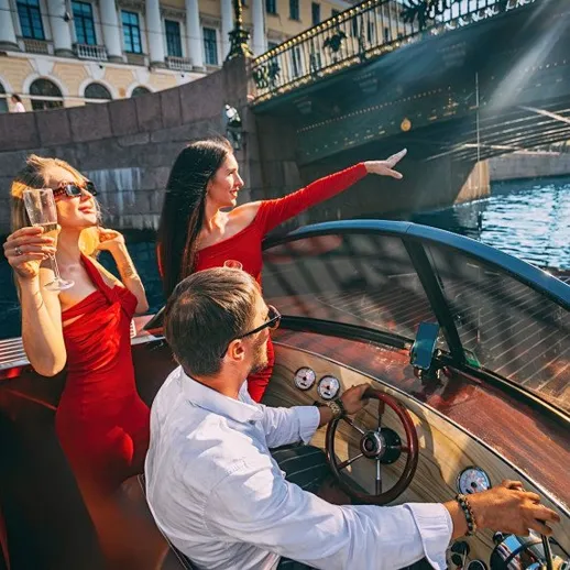 Друзья наслаждаются прогулкой на лодке по реке в центре Санкт-Петербурга в солнечный день