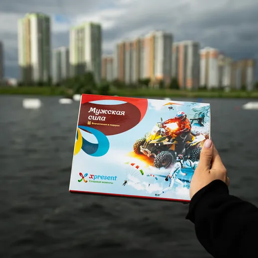 Картонная коробка с надписью на фоне городских зданий у воды в серый облачный день