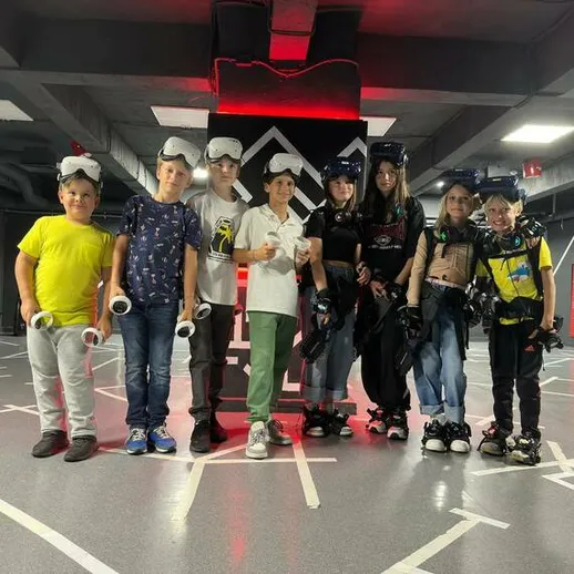 Дети участвуют в виртуальном игровом процессе в игровом центре в вечернее время