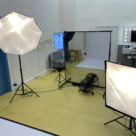 Освещенное фотостудийное пространство с оборудованием для съемки в помещении