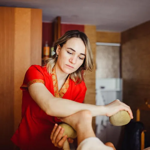 Женщина проводит массаж с использованием камней в уютном спа-салоне