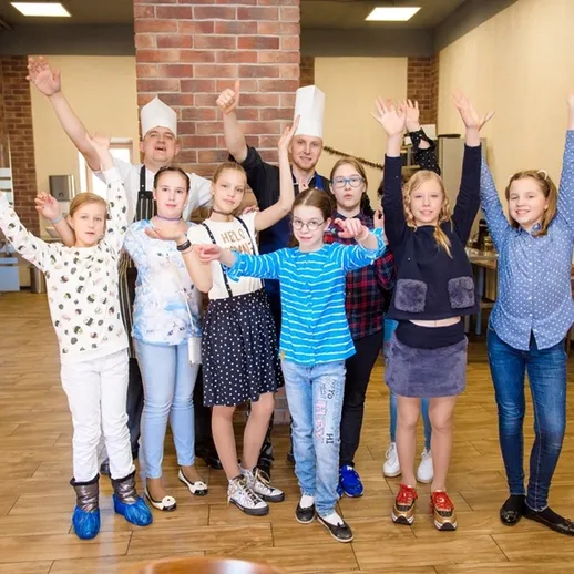 В группе детей и поваров на кулинарном мастер-классе в ресторане