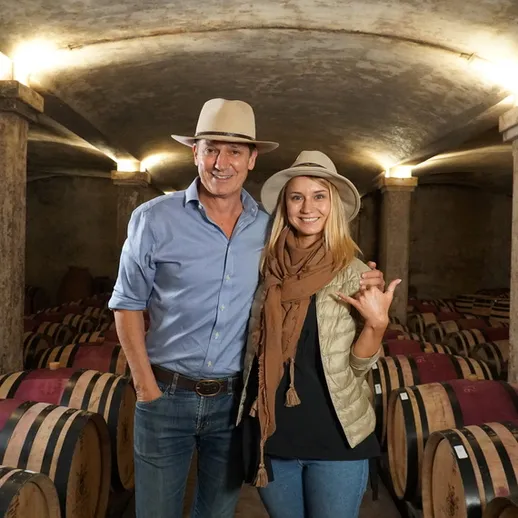 Пара позирует в винном погребе среди бочек с вином