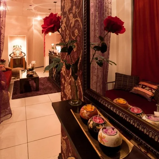 Уютный интерьер спа-салона с декоративными цветами и светильниками, созданный для расслабления клиентов в вечернее время