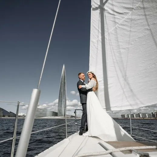 Молодожены на яхте в открытом море во время свадебной церемонии под ясным небом