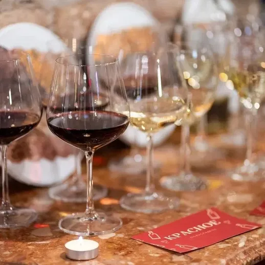 Вино и закуска на столе с разноцветными бокалами на вечеринке в уютном ресторане