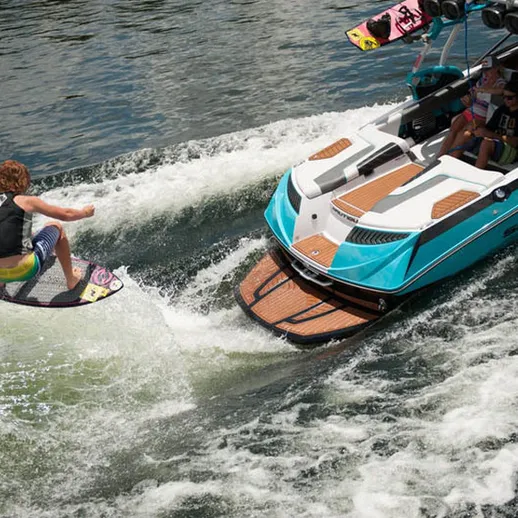 Серфинг на озере с лодкой в солнечный день, спортсмен демонстрирует трюки на воде