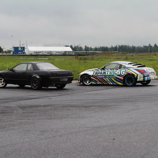 Автомобили на дрифтовом тренировочном мероприятии на закрытом автодроме в пасмурный день