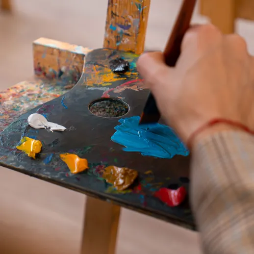 Мастера живописи создают произведение в мастерской с палитрой и красками на столе во время творческого занятия