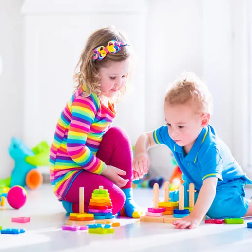 Дети играют с цветными строительными блоками в яркой комнате в солнечный день