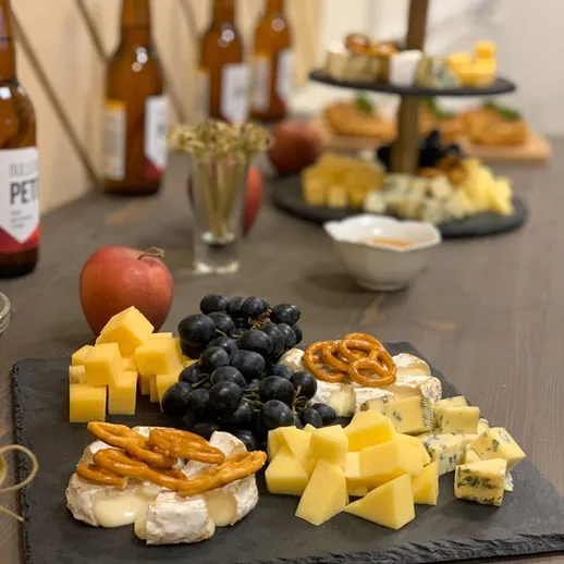 Ассорти из сыра и закусок к пиву на столе в уютном кафе во время вечеринки