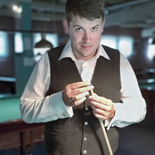 Мужчина в жилете готовится к игре в бильярд в клубе в вечернее время