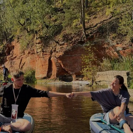 Молодежь наслаждается летом на каноэ у живописного берега реки в лесу