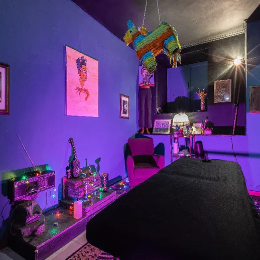Яркая комната с фиолетовыми стенами, украшенная гирляндами и музыкальными инструментами, уютно освещенная вечером