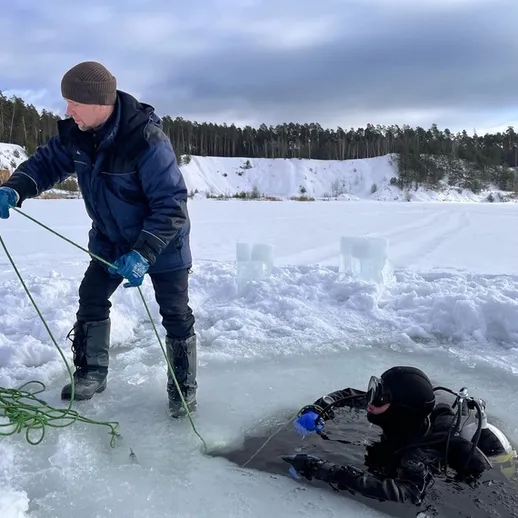 Подводное погружение в зимнем озере с использованием водолазного снаряжения и помощи на берегу