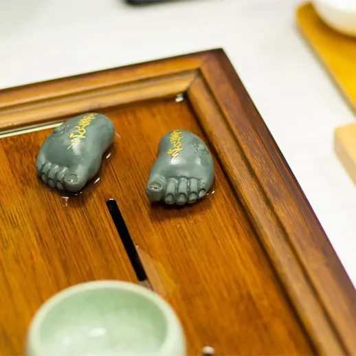 Мастера игры в го используют каменные фигуры в виде ног во время турнира в Китае