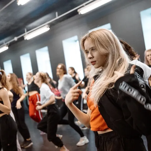 Танцевальный класс в студии с участниками, занимающимися хореографией в вечернее время