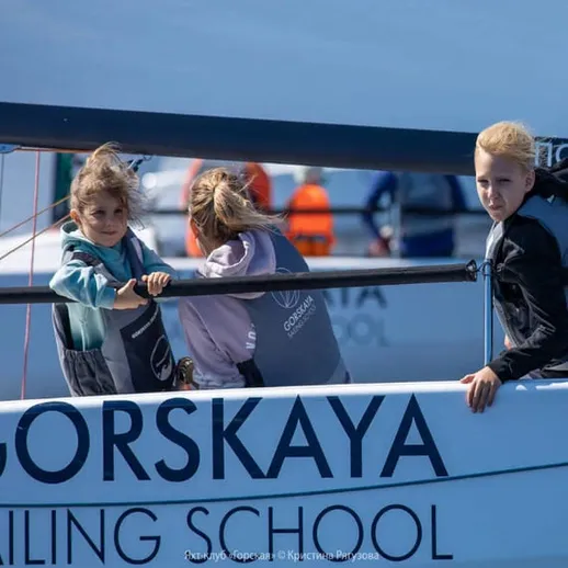 Дети обучаются парусному спорту в школе на благоустроенной пристани летом на берегу моря