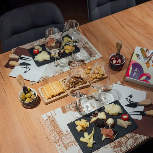 Веселая дегустация сыров и закусок на деревянном столе в уютном кафе