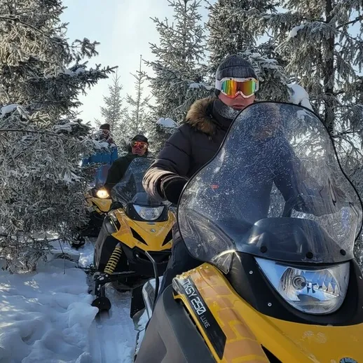 Катание на снегоходах по зимнему лесу в солнечный день с друзьями