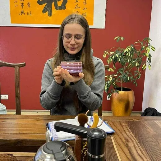 Молодая женщина с длинными волосами изучает упаковку с косметикой в уютном кафе