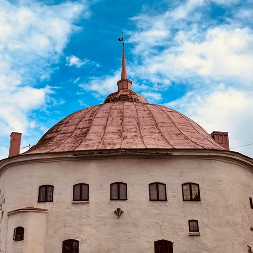 Купол старинного здания с медной крышей на фоне синего неба в центре города в солнечный день