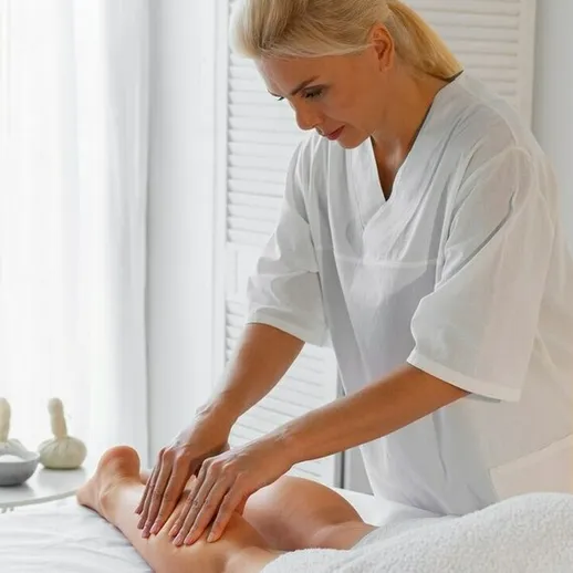 Массажистка проводит расслабляющий массаж ног клиенту в светлом массажном кабинете