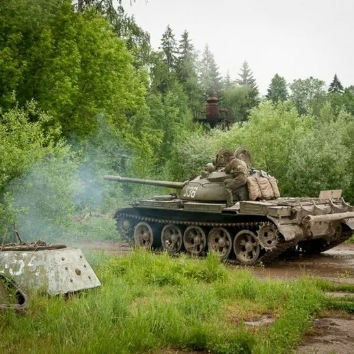 Старая советская танк Т-55 на заброшенной военной базе в лесу в облачный день