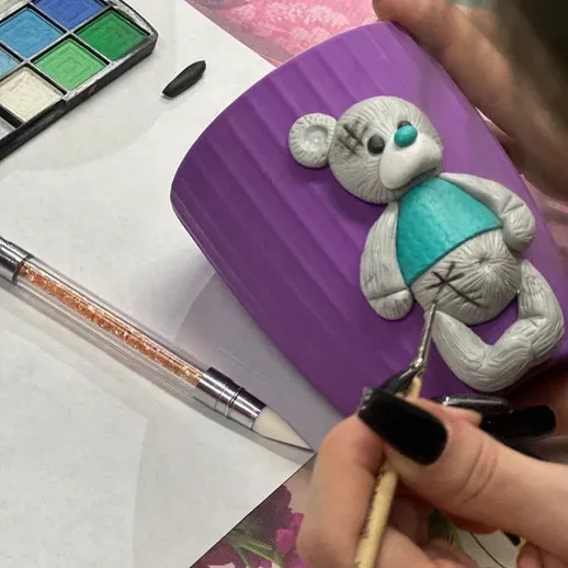 Ручная работа по созданию фигурки медведя на фиолетовой кружке в творческой мастерской