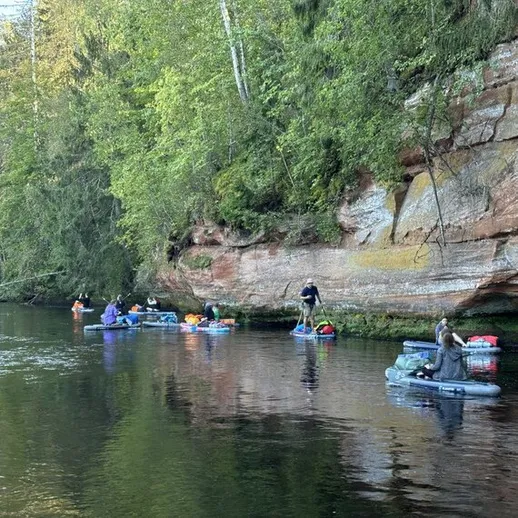 Групповой сплав на плотах по реке в живописном лесу осенью