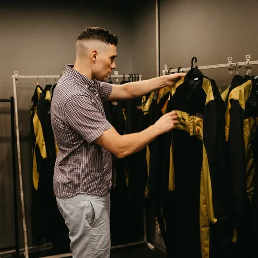 Мужчина выбирает костюм для активного отдыха в специализированном магазине одежды в помещении